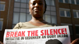 Frau mit Transparent. Aufschrift: Break the silence Rechte: WDR